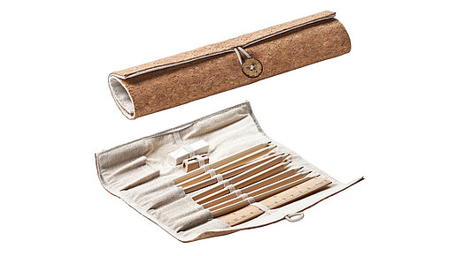 Vorne eine geöffnete Rolle mit Schreibmaterial, dahinter die Rolle mit Knopfverschluß geschlossen.