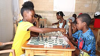 Mit Freude lernen Mädchen und Jungen in Haiti Schach. © Plan International