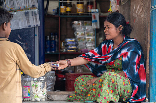 Ranju und Kunde vor Lebensmittelgeschäft