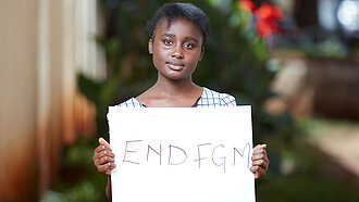 Frau mit Schild "End FGM"