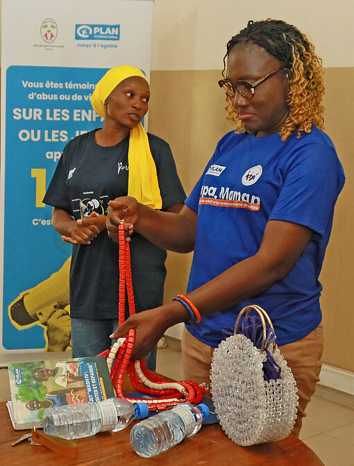 Frauen zeigen bunte Ketten aus Perlen