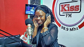 Eine Frau sitzt im Radio-Studio