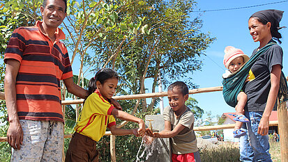 Rosalina (r.) und ihre Familie haben nun Zugang zu sauberem Wasser und müssen es nicht mehr aus einem Bach holen. © Plan International Rosalina (r.) und ihre Familie haben nun Zugang zu sauberem Wasser und müssen es nicht mehr aus einem Bach holen. © Plan International