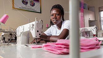 Mädchen sitzt an einer Nähmaschine