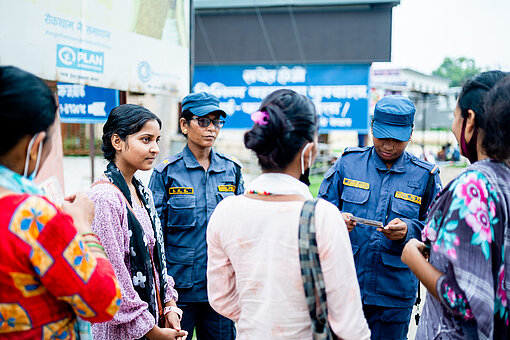 Junge Frauen sprechen mit Polizeibeamten