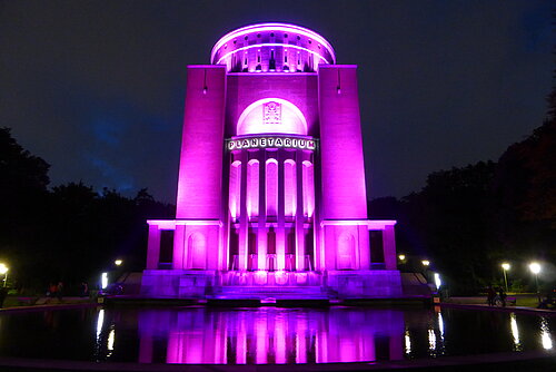 Das Gebäude des Planetariums Hamburg wird im Dunkeln pink angeleuchtet.