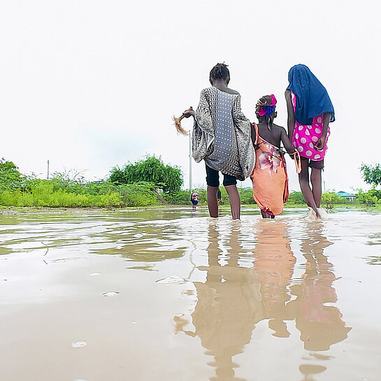 Frauen waten bis zu den Knöcheln im Wasser