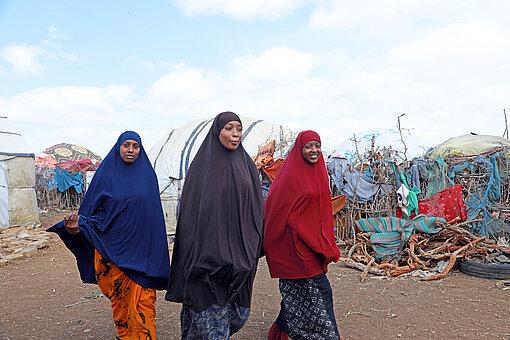 Aisha, Munira und Hibo gehen durch das Binnenvertriebenenlager in Baidoa