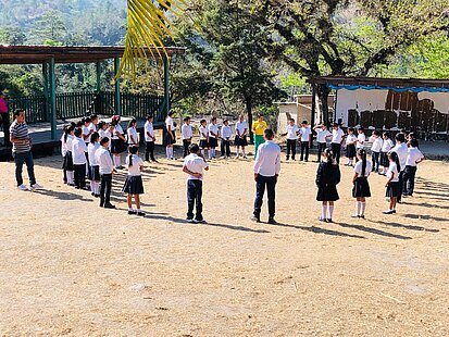 Kinder stehen im Kreis auf einem Schulhof