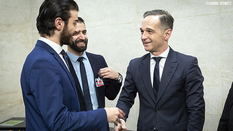 Karim schüttelt Heiko Maas die Hand.