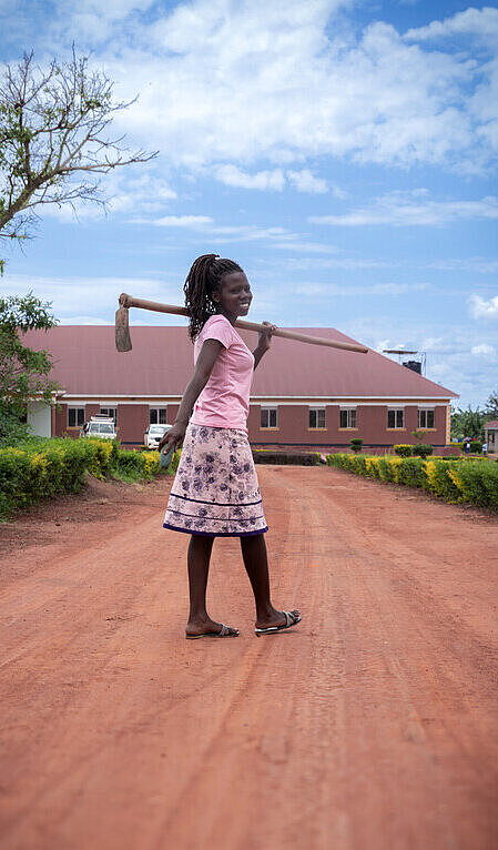 Daphine möchte das Leben junger Menschen verändern Mädchen steht auf einem Weg in Uganda