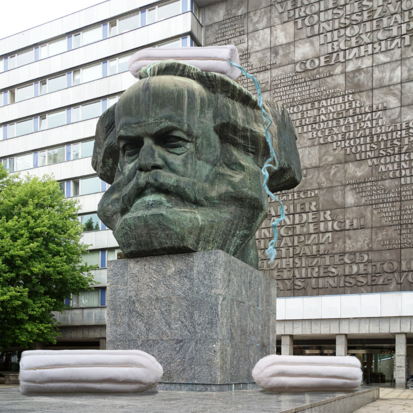 Auf und neben dem Kopf der Karl Marx Statue in Chemnitz liegen drei riesige Tampons