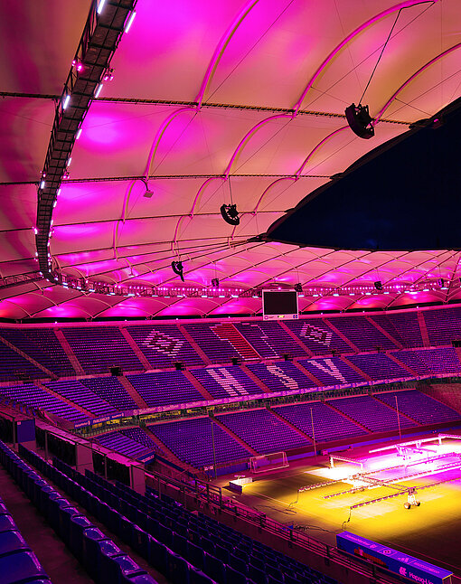 Tribünen eines pink erleuchteten Fußballstadions