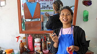 Eine junge Friseurin steht in ihrem Beauty-Salon