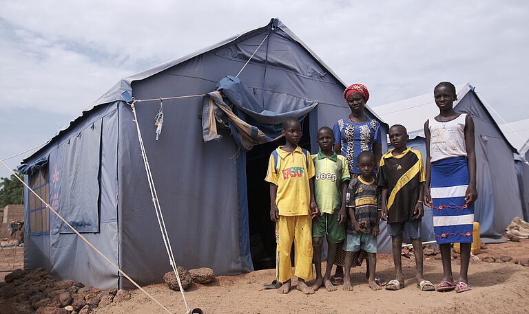 Familie vor ihrem Zelt im Geflüchtetenlager