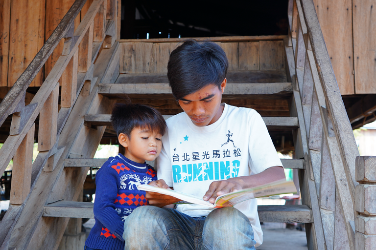 Junger Vater liest mit seinem Sohn auf der Treppe