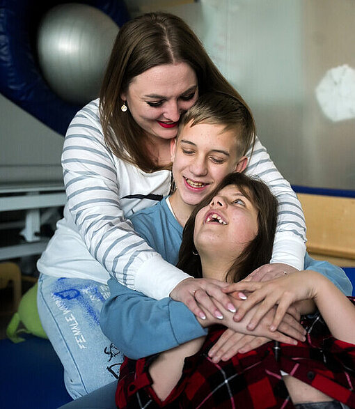 Nataliia hält ihre beiden Kinder im Arm. Alle drei lachen.