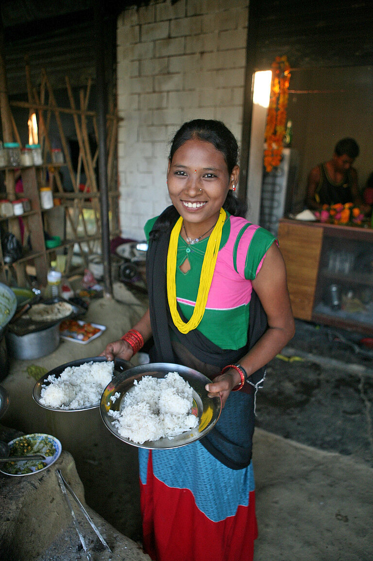 Ein Mädchen serviert Reis