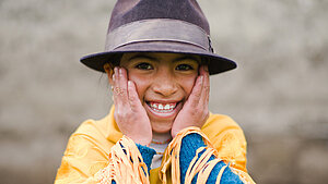 Ein Mädchen aus Ecuador mit einem Hut und traditioneller Kleidung, das als Beispiel für Kinder dient, die durch Testamentsspenden Unterstützung erhalten könnten.