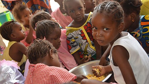 In einer von Plan eingerichteten Kantine in Timbuktu erhalten Kinder regelmäßige Mahlzeiten.