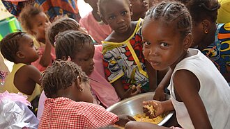 In einer von Plan eingerichteten Kantine in Timbuktu erhalten Kinder regelmäßige Mahlzeiten.