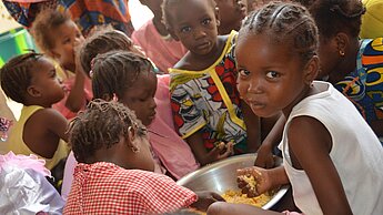 In einer von Plan eingerichteten Kantine in Timbuktu erhalten Kinder regelmäßige Mahlzeiten.