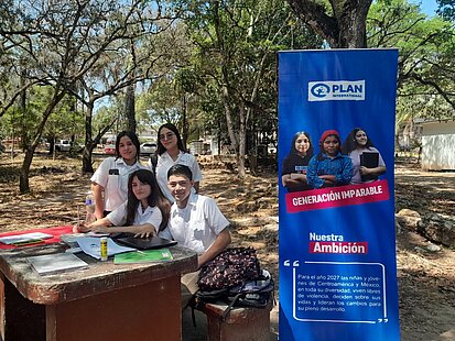 Jugendliche sitzen gemeinsam an einem Schreibtisch
