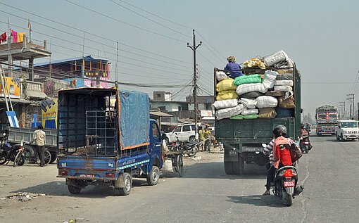 Lastwagen sind nahe der nepalesischen Industriestadt Biratnagar unterwegs