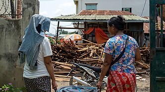 Zwei Frau vor den Trümmern eines zerstörten Hauses