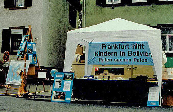 Ein Aktionsstand mit Plakat, auf dem Frankfurt hilft Kindern in Bolivien steht