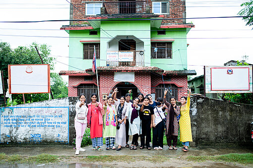 Eine Gruppe junger Frauen steht für ein Gruppenbild vor einem Hauseingang