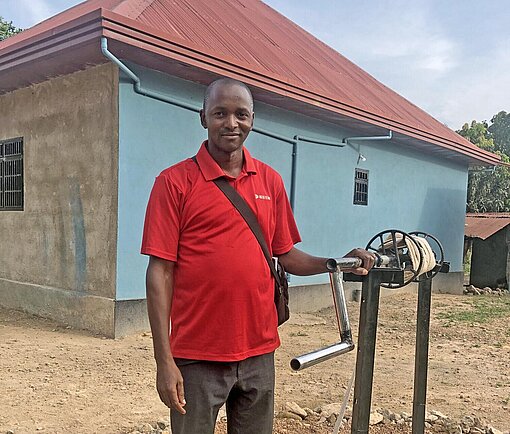 Ein junger Mann steht an einem Brunnen in Guinea