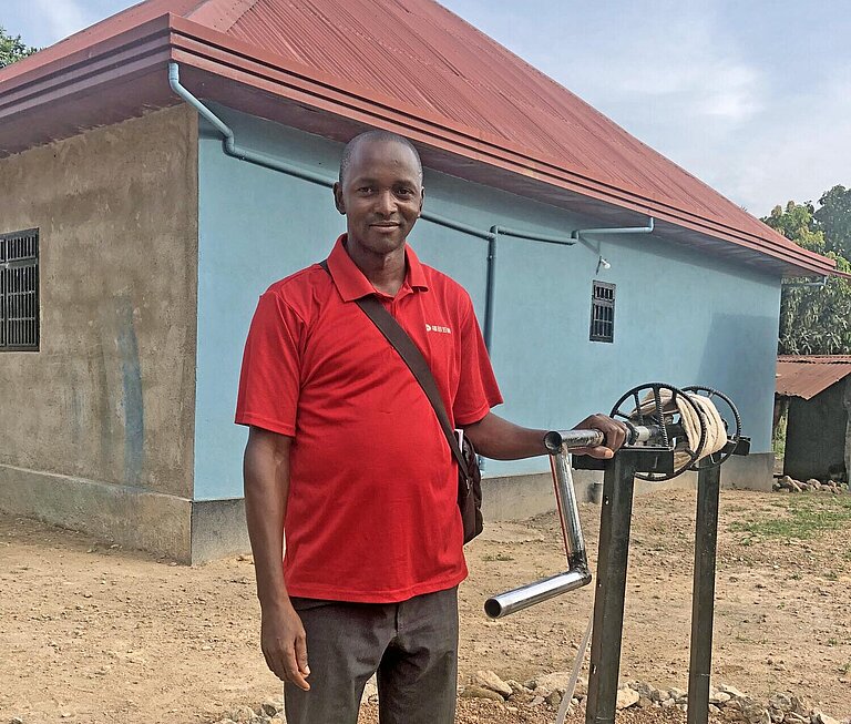 Ein junger Mann steht an einem Brunnen in Guinea