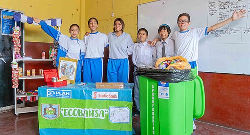 Mitglieder des Ecobansa-Projekts an ihrer Schule in Lima mit Ideengeber Jesús (re.) Mädchen und Jungen stehen in einer Reihe zusammen und lachen