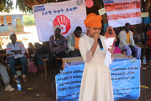 Ein Mädchen hält ein Mikrofon und spricht vor einer Gruppe zur Sensibilisierung gegen geschlechtsspezifische Gewalt in Äthiopien