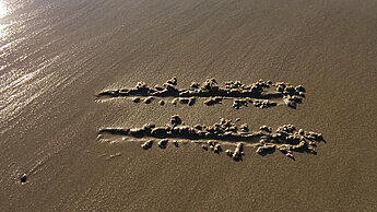 Gleichzeichen am Strand