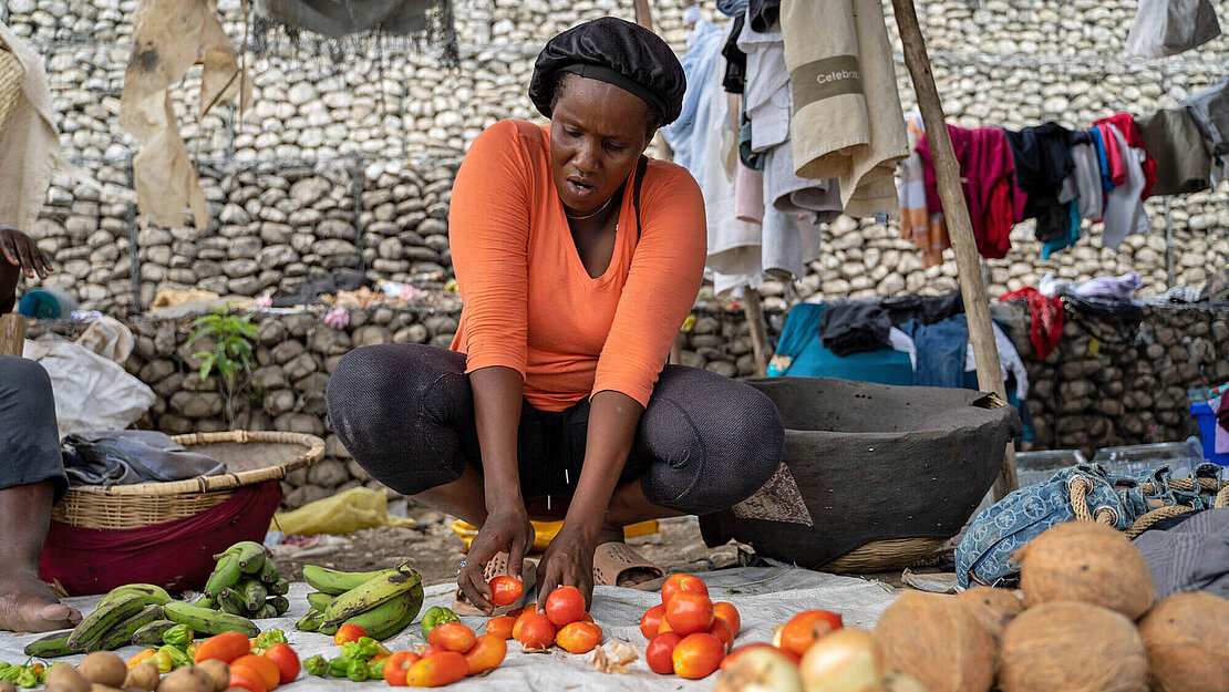 Eine Händlerin bietet Gemüse an
