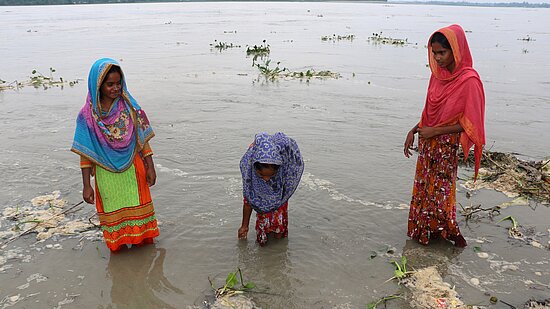 Drei jugendliche Mädchen aus Bangladesch stehen im Wasser