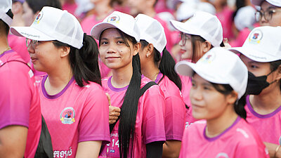 Eine Gruppe von Mädchen in pinken Sport-Shirts wartet darauf, dass der Marathon für Kinderrechte startet.