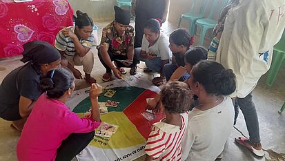 Menschen knien um ein Plakat zu positiver Erziehung