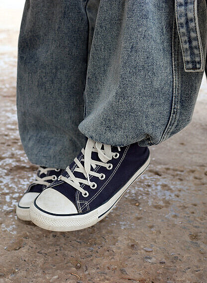 Weite Teile der Fluchtrouten legen die Kinder oft zu Fuß zurück Turnschuhe und Jeans eines Mädchens