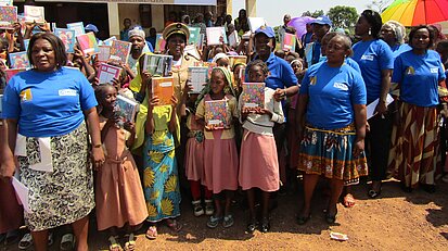 Schulkinder halten ihre Hefte hoch