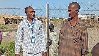 Zwei Männer unterhalten sich an einem Brunnen