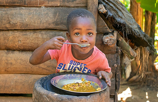 Unter anderem in Haiti unterstützt Plan International die Nothilfe für mangelhaft ernährte Kinder wie Dawens (5) Ein Junge isst von einem Teller