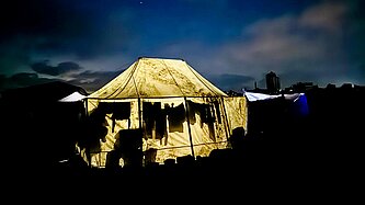 Ein erleuchtetes Zelt bei Nacht in der Nähe eines Verteilungspunkts in Gaza