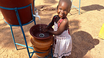 Das Bild ist aus einem vergleichbaren Projekt in Burkina Faso. Ein Mädchen wäscht ihre Hände.