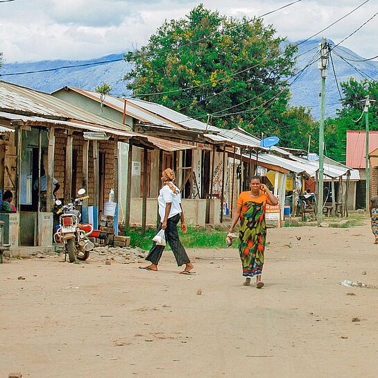Blick auf eine sandige Dorfstraße mit einfachen kleinen Häusern