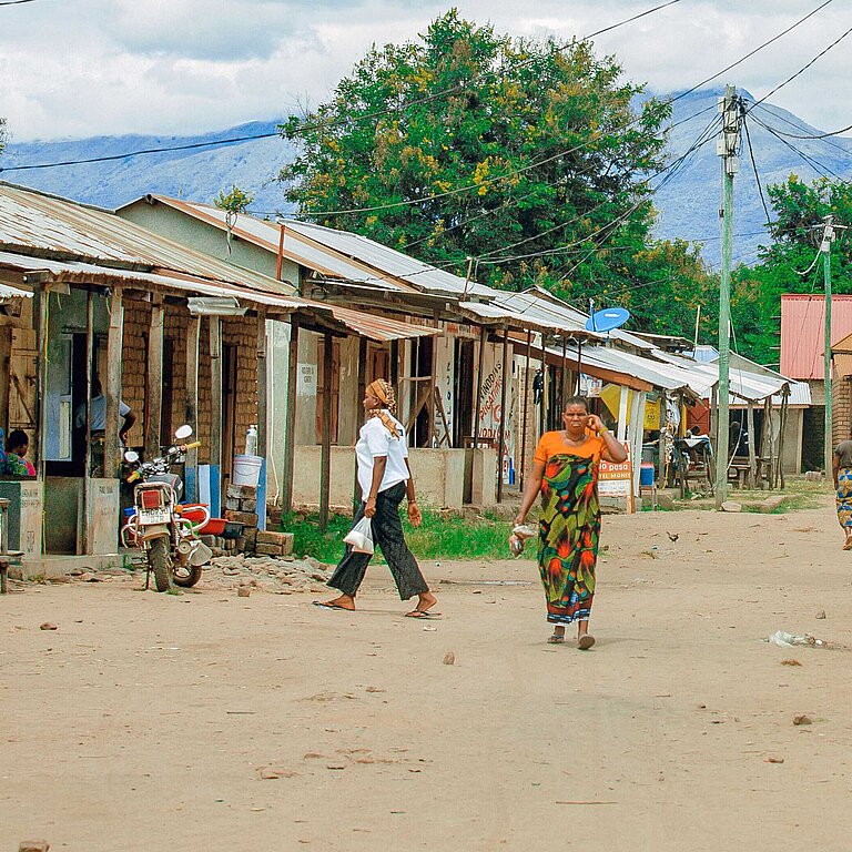 Blick auf eine sandige Dorfstraße mit einfachen kleinen Häusern