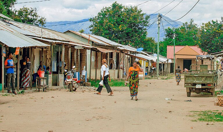 Blick auf eine sandige Dorfstraße mit einfachen kleinen Häusern