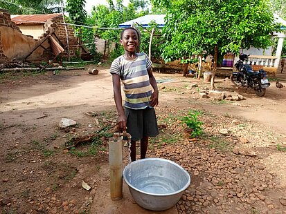 Ein Mädchen holt Wasser an einer Wasserstation
